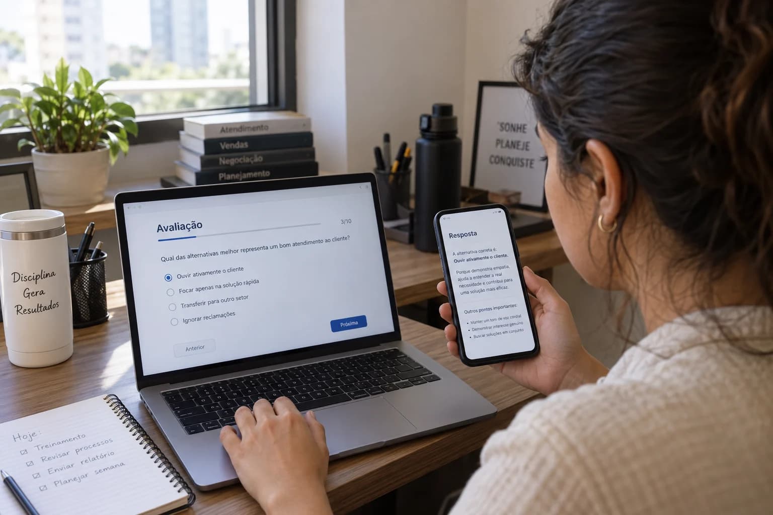 Participante consulta uma resposta no celular enquanto preenche uma avaliação no computador.